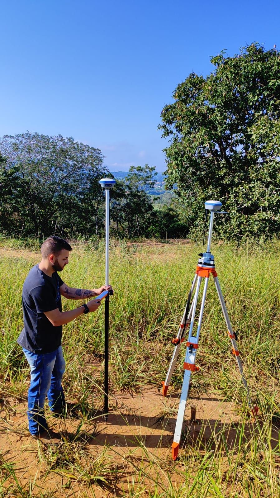 Técnico operando GPS RTK em campo aberto